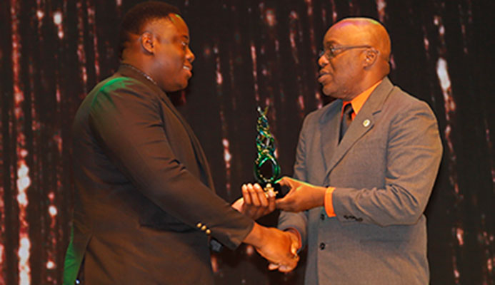 TOP 10 NOMINEE Field athlete Akeem Stewart, left, is presented with his trophy by Kelvin Charles, Chief Secretary, Tobago House of Assembly, during the 2016 First Citizens Sports Foundation 2016 "Sportwoman of the Year" and "Sportsman of the Year" award function to be held at Queen's Hall, St Ann's on Friday night.