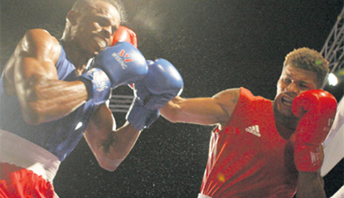 T&T’s Michael Alexander, right, catches Jamaica’s Damion Williams with a punch to the head, during Tuesday night’s Boxing At the Castle duel. Alexander won the fight by unanimous decision. PHOTO: WALTER ALIBEY