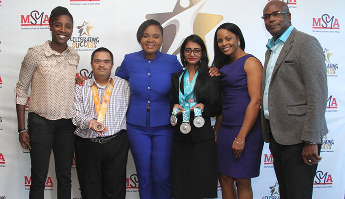 Minister of Sport and Youth Affairs Shamfa Cudjoe, third from left, takes a photo with cricketer Britney Cooper, from left, bocce players Bernard Singh and Alicia Khan, cricketer Merissa Aguilleira and TT’s first Olympic gold medallist Hasely Crawford at the Rewards, Recognition and Cheque Presentation Ceremony at the National Racquet Centre, Tacarigua, yesterday.