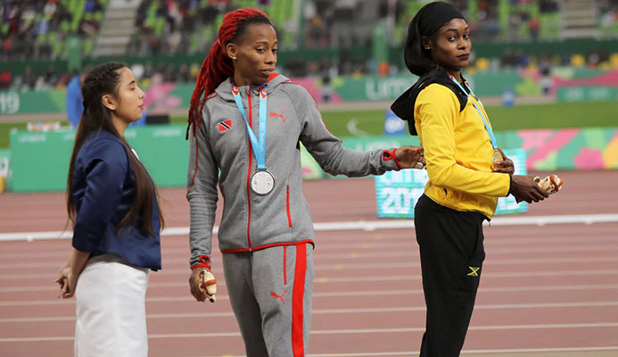 Gold medallist Elaine Thompson of Jamaica (right) and silver medallist Michelle-Lee Ahye of TT stand on the podium for the women’s 100m at the Pan American Games in Lima, Peru on Wednesday.