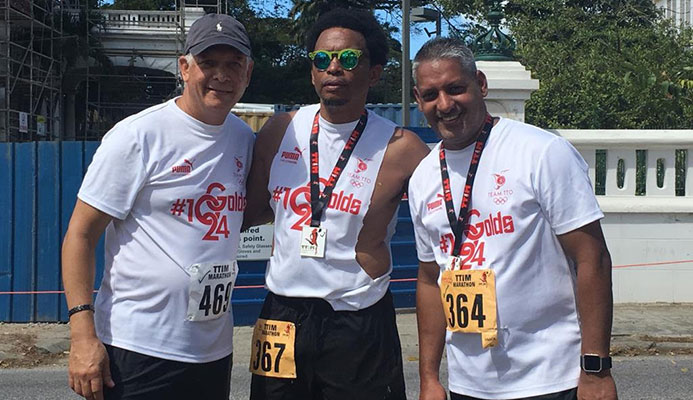 TTOC president Brian Lewis,centre, is flanked by Agriculture Minister Clarence Rambharat,left, and Mayor of Port of Spain Joel Martinez after they completed the TT International Marathon, on Sunday, at the Queen's Park Savannah.