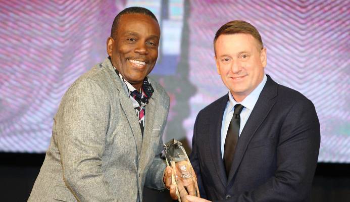 Trinidad and Tobago Cycling Federation technical director Erin Hartwell receives the Sports Personality of the Year award from Tunapuna MP Esmond Forde during the T&T Olympic Committee’s annual end of year awards function at the Hyatt Regency, Port-of-Spain, last Sunday.