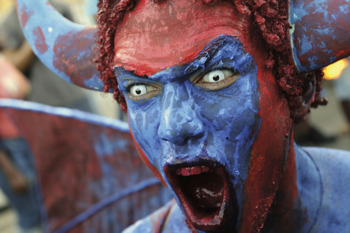 A menacing blue devil intimidates the crowd. Photo by Atiba Williams