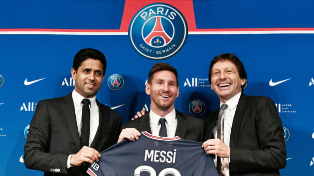 Paris Saint-Germain’s Qatari President Nasser Al-Khelaifi (L) and Paris Saint-Germain’s Sporting Director Leonardo Nascimento de Araujo (R) pose along side Argentinian football player Lionel Messi (C) as he holds-up his number 30 shirt during a press conference at the French football club Paris Saint-Germain’s (PSG) Parc des Princes stadium in Paris on August 11, 2021. Stephane De Sakutin | AFP | Getty Images