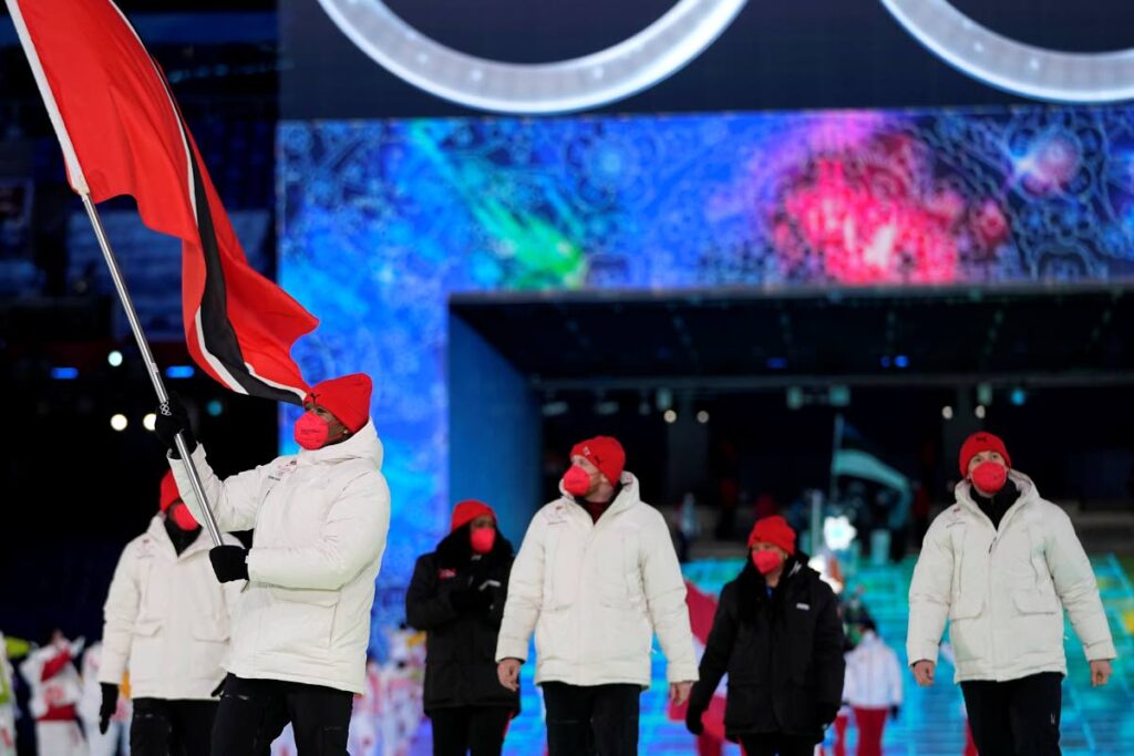 Andre Marcano, of Trinidad and Tobago, carries his national flag into the stadium during the opening ceremony of the 2022 Winter Olympics, on Friday, in Beijing, China. (AP PHOTO) -