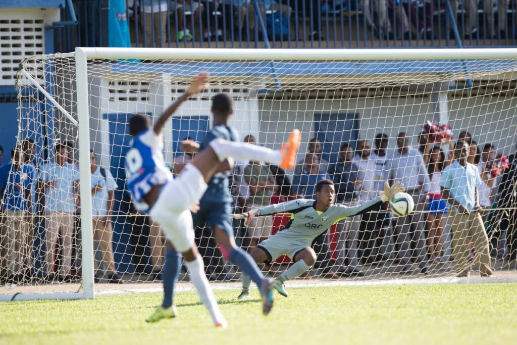 In this September 21, 2016 file photo, St Mary’s Tyrese Spicer, left, scores past a diving Queen’s Royal College goalie Kern Thomas in a Secondary Schools Football League Premeirship match at Serpentine Road, St Clair. - File Photo (Image obtained at newsday.co.tt)