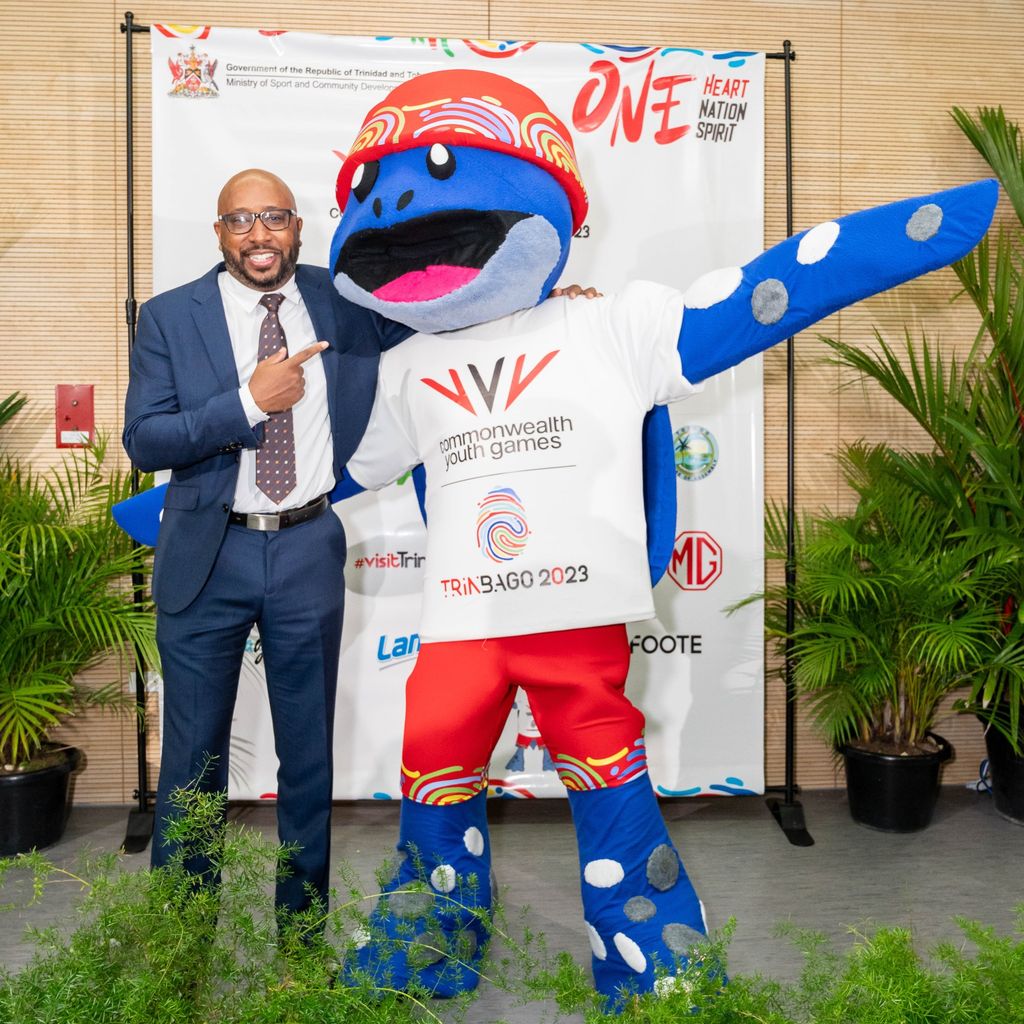 Head of the corporate social responsibility at NGC, Myles Lewis, hugs Cocoyea, the mascot of the Commonwealth Youth Games, at the media launch of the event on Wednesday.  Anthony Wilson (Image obtained at guardian.co.tt)