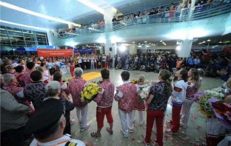 Proud: Russia's athletes, who scooped a total of 82 medals at the London Games, were showered with flowers and petals when they arrived in Moscow