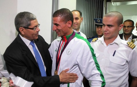 Congrats: Algerian gold medal winner Taoufik Makhloufi, centre, was greeted by the country's minister of sport Hachemi Dijar, left, upon his return