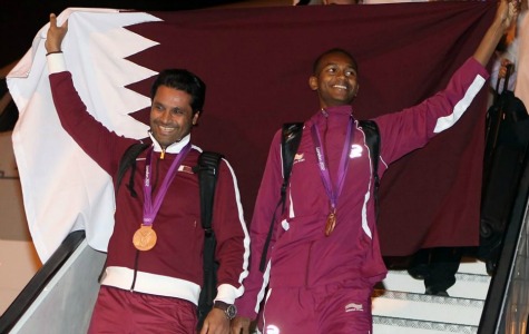 Medal winners from Qatar's Olympic team hold up their national flag as they arrive at Doha International Airport. Nasser al-Attiyah, left, won bronze in the men's skeet final in shooting, while Mutaz Essa Barshim, won bronze in the high jump