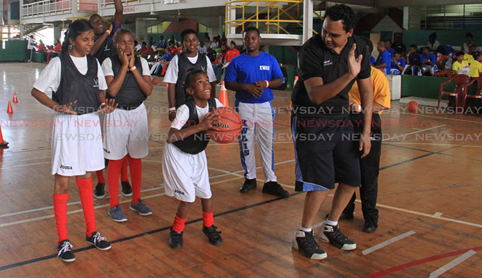 Nigel Clarke, right, shows Rayanna Flanders how to shoot during a basketball drill at the Special Olympics National Games, held at the Jean Pierre Complex, yesterday. Nigel Clarke, right, shows Rayanna Flanders how to shoot during a basketball drill at the Special Olympics National Games, held at the Jean Pierre Complex, yesterday.